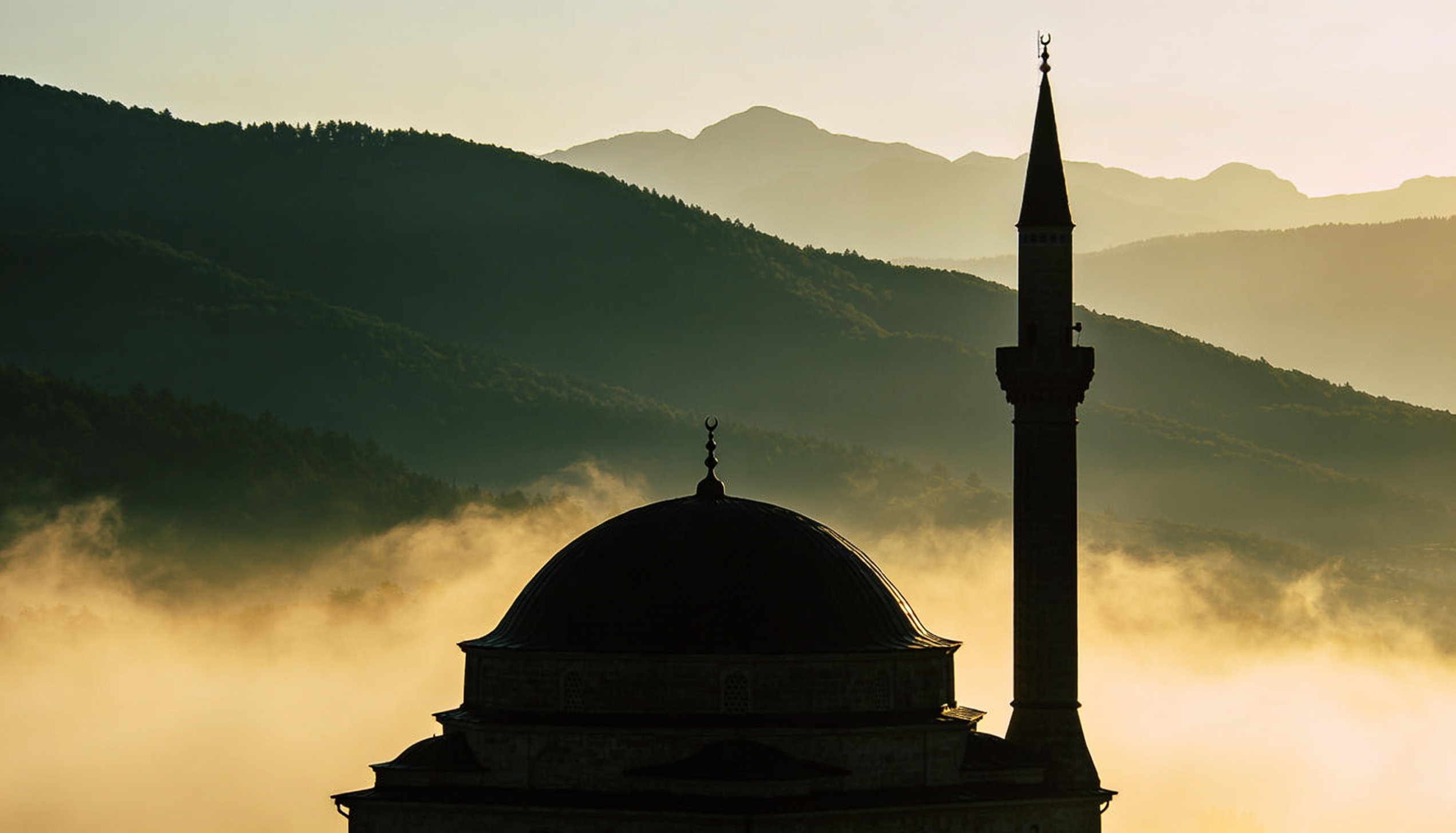 Banja Luka'da yeniden inşa edilmiş Arnaudija Camii'nin açık avlusu. Ön planda yıkantılanmış taş döşeme, arka planda restore edilmiş beyaz sıvalı cami cephesi ve ince minaresi. Doğal gün ışığı, hafif bulutlu Balkan gökyüzü. İnsan yok, yüz yok — documentary fotoğraf disiplini.